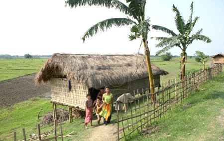 Téléchargez les photos : Famille devant les chalets en bambou à majuli île, Assam, Inde - en image libre de droit