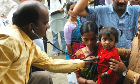 Photo for A doctor examines a child in medical camp for 26 July 2005 flood affected residents, fears of epidemic, Bombay Mumbai, Maharashtra, India - Royalty Free Image