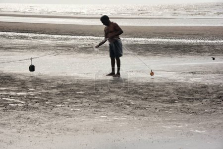Foto de Pescador reparación de la red de pesca, Playa del Bhagal, Valsad, Gujarat, India, Asia - Imagen libre de derechos