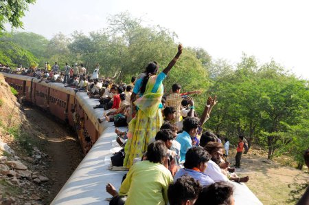 Téléchargez les photos : Personnes prenant des risques en voyageant sur le toit du train ; Goram ghat ; Marwar Junction ; Rajasthan ; Inde - en image libre de droit