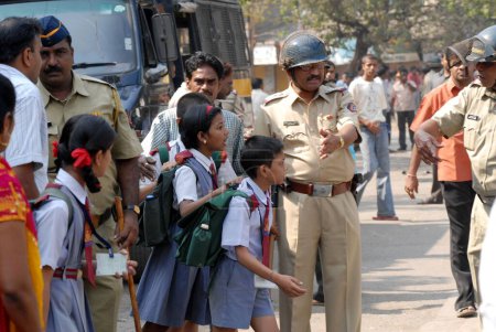Photo for Police personnel leading school children to safe places after the Dalit community resort to violent protests, Bombay now Mumbai, Maharashtra, India - Royalty Free Image
