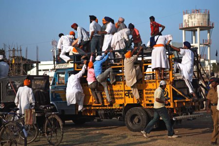 Foto de Devotos de Sikh escalando en camión para la consagración de sikh guru granth sahib, Nanded, Maharashtra, India 1- Noviembre-2008 - Imagen libre de derechos