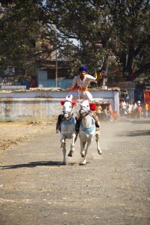 Photo for Nihang or Sikh warriors performing stunts, cultural events for 300th year celebrations of Consecration of perpetual Guru of Sikh Guru-Granth at Khalsa Sports ground in Nanded, Maharashtra, India 30-October-2008 - Royalty Free Image