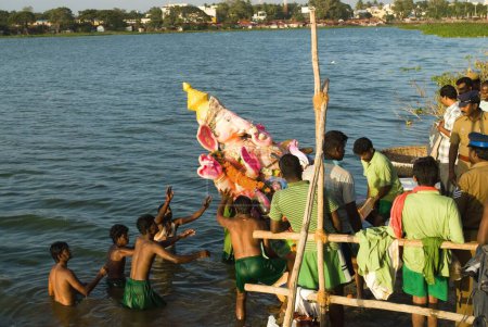 Téléchargez les photos : Personnes portant idole de lord ganesh plongeant dans l'étang sur la fête ganpati ; Muthannankulam ; Coimbatore ; Tamil Nadu ; Inde 2009 - en image libre de droit