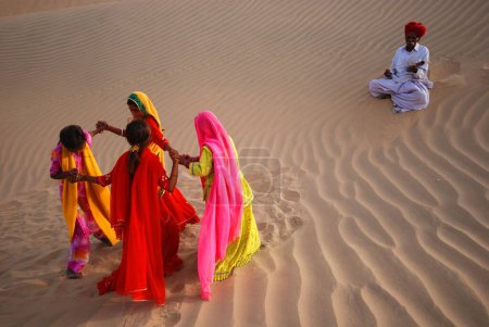 Photo for Girls dancing ghoomer on sand dune, Khuhri, Jaisalmer, Rajasthan, India - Royalty Free Image