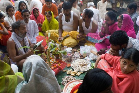 Photo for Brahmin reading scripture and performing satya narayan pooja at Babu Ghat, Kolkata, India - Royalty Free Image