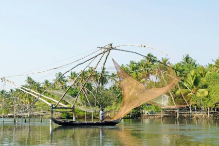 Foto de Pescador reparando la red de pesca china en los remansos de Cherai; Kerala; India - Imagen libre de derechos