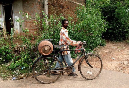 Photo for Man carrying cylinder on cycle ; Bhubaneswar ; Orissa ; India - Royalty Free Image