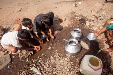 Photo for Children drinking water from puddle, Shahapur, Mumbai, Maharashtra, India, Asia - Royalty Free Image
