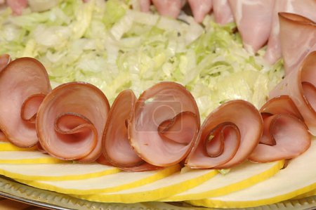 Photo for Non vegetarian food , cold platter with smoked ham and honey melon and bed of iceberg salad bed , Rose Shaped round ham slices decorated platter - Royalty Free Image