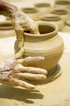 Photo for Pottery ; traditional Indian kumbhar ( potter ) hands giving shape to Clay pot ; uttar pradesh ; india - Royalty Free Image