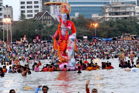 Téléchargez les photos : Une énorme idole de Ganesh (dieu à tête d'éléphant) est immergée dans la mer à Girgaum Chowpatty, Bombay maintenant Mumbai, Maharashtra, Inde - en image libre de droit