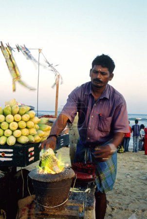 Foto de Hombre asando maíz, Madras Chennai, Tamil Nadu, India - Imagen libre de derechos