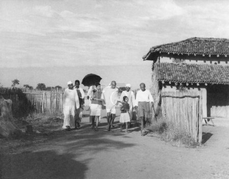 Foto de Mahatma Gandhi, Abha Gandhi con paraguas, JC Kumarappa r y otros en Sevagram Ashram, 1938 NO MR - Imagen libre de derechos