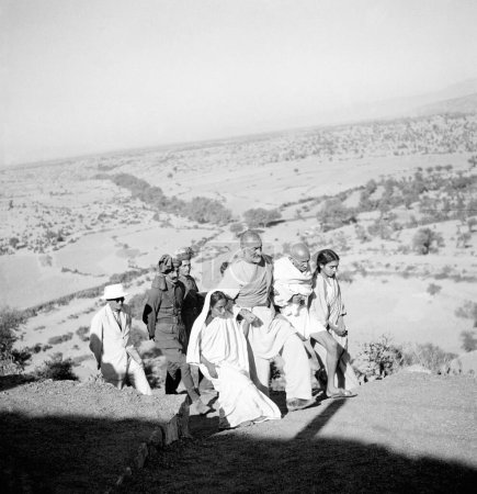 Photo for Sushila Nayar, Mahatma Gandhi, Khan Abdul Gaffar Khan, Amtus Salam and others walking in the countryside during Mahatma Gandhis visit to the North West Frontier Provinces to Afghanistan, October 1938 - Royalty Free Image