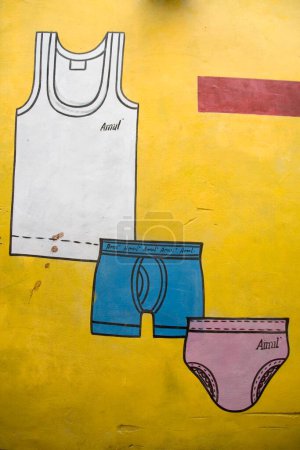 Foto de Pintura de pared de color amarillo anuncio de ropa interior masculina; Pueblo dilwara; Udaipur; Rajastán; India - Imagen libre de derechos