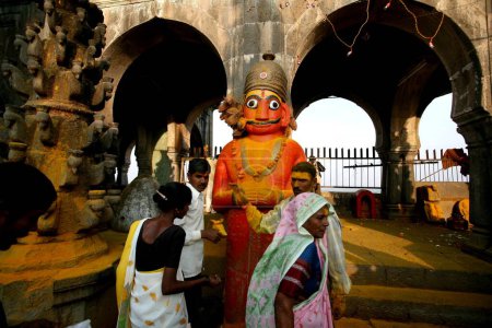 Téléchargez les photos : Les dévots obéissant à la grande statue orange du démon Malla plongé dans la poudre de curcuma qui est dévot du seigneur Khandoba au temple Jejuri, pune, Maharashtra, Inde - en image libre de droit