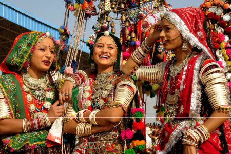 Foto de Chicas en joyería tradicional y traje de rajasthani tener charla entre sí, feria de Pushkar, Rajastán, India - Imagen libre de derechos