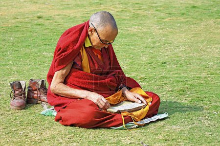 Téléchargez les photos : Moine bouddhiste lisant les Écritures, Sanchi, Madhya Pradesh, Inde - en image libre de droit