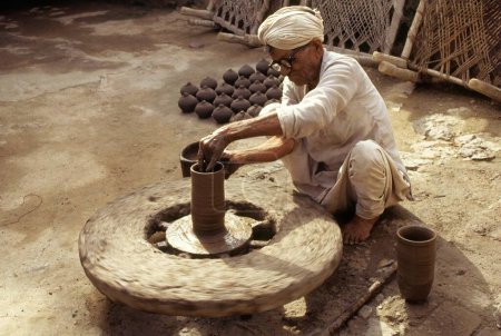 Photo for Pottery , potter giving shape to clay pot on wheel - Royalty Free Image