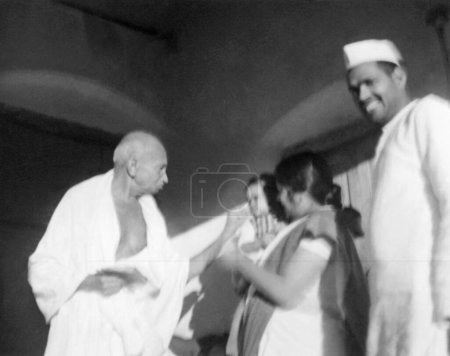 Téléchargez les photos : Mahatma Gandhi, Uma Om Agarwal et Radhakrishna Bajaj à Wardha, 1945, Inde - en image libre de droit