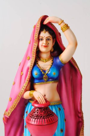 Figurine en argile, statue de la jeune fille rajasthani avec sari pallu sur la tête et tenant pot coloré