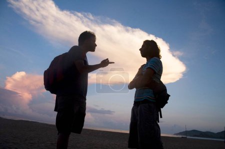 Foto de Dos figuras de silueta humana hablando; Playa de Palolem; Goa; India - Imagen libre de derechos