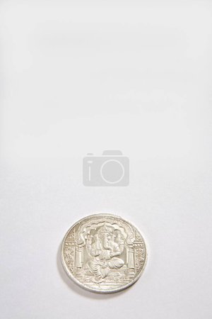 Konzept, Silbermünze des Gottes Ganesh auf weißem Hintergrund