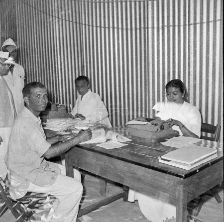 Foto de Viejo vintage 1900s imagen en blanco y negro del empleado de oficina indio mesa de trabajo manual máquina de escribir India 1940 - Imagen libre de derechos