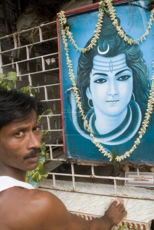 Photo for Man Cleaning Roadside Temple of God Shiva, Kolkata, West Bengal, India - Royalty Free Image