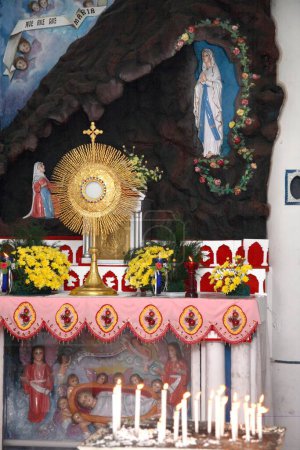 Téléchargez les photos : Sacrement béni et bougies allumées devant un autel conservé dans la salle de prière souterraine de la cathédrale Notre-Dame de Lourdes ; Thrissur ; Inde - en image libre de droit