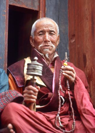 Photo for Monk counting bead and rotating prayer wheel - Royalty Free Image
