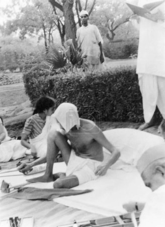 Téléchargez les photos : Mahatma Gandhi spinning, New Delhi, 1939, Sushila Nayar, Mahadev Desai, Inde - en image libre de droit