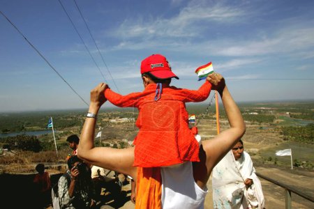 Foto de Niño sentado en el hombro de sus padres bajando de la colina después de Mahamasthakabhisheka, importante festival de Jain celebrado una vez cada doce años en Shravanabelagola, distrito de Hassan, estado de Karnataka, India febrero 2006 - Imagen libre de derechos