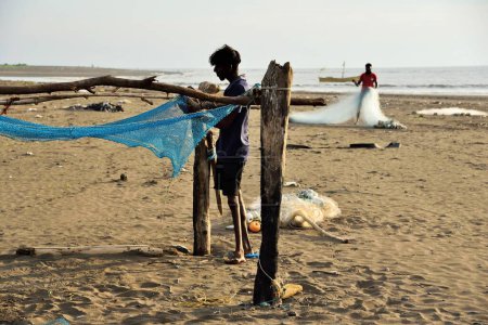 Téléchargez les photos : Pêcheur réparant filet de pêche, Surwada Beach, Gujarat, Inde, Asie - en image libre de droit
