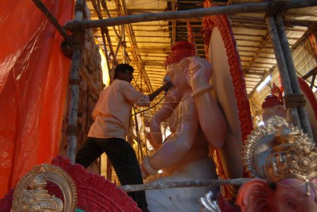 A sculptor makes lord Ganesh idols from plaster of Paris in a workshop at Lalbaug for Ganesh ganpati festival ; Bombay now Mumbai ; Maharashtra ; India