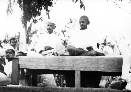 Foto de Mahatma Gandhi y Thakkar Bapa en una reunión de oración en la zona afectada por disturbios de Noakhali Bengala Oriental, noviembre - Imagen libre de derechos