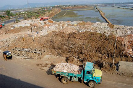 Photo for Trucks dump debris on the salt pan land on the Eastern Express Highway in Bombay now Mumbai ; Maharashtra ; India - Royalty Free Image