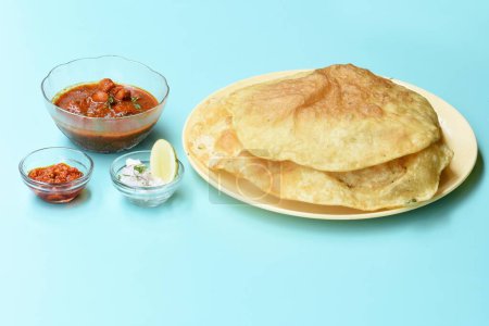 Indisches Gericht scharfes Kichererbsen-Curry, auch bekannt als Chole Bhatura und Chana Masala oder Chole oder Kichererbsen-Masala-Curry, traditionelles nordindisches Mittagessen, serviert mit gebratenem Puri oder Fladenbrot, selektiver Fokus