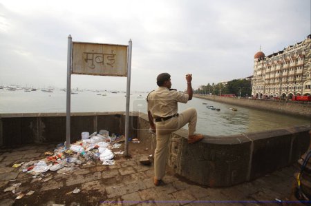 Téléchargez les photos : Un policier de Mumbai filme l'hôtel Taj Mahal dans un téléphone portable après avoir débusqué un terroriste de l'hôtel Taj Mahal à Bombay Mumbai, Maharashtra, Inde - en image libre de droit