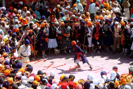 Foto de Guerreros nihang o sij realizando acrobacias con armas durante las celebraciones de Hola Mohalla en el sahib de Anandpur en el distrito de Rupnagar, Punjab, India - Imagen libre de derechos