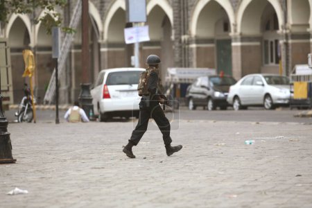 Foto de Comando de la Guardia de Seguridad Nacional del NSG corriendo durante el tiroteo con militantes dentro del Taj Mahal Hotel ataque terrorista por Deccan Mujahideen en Bombay Mumbai, Maharashtra, India 28 _ November _ 2008 - Imagen libre de derechos