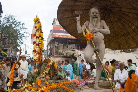 Hindu saint naga baba Shivdasgiri warping penis with trishul rod in Varanasi on Ganga river ; Uttar Pradesh ; India MR707A