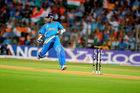 Téléchargez les photos : Le batteur indien Sachin Tendulkar a terminé sa course lors de la finale de la Coupe du monde 2011 entre l'Inde et le Sri Lanka au stade Wankhede, le 2 avril 2011 à Mumbai, Inde - en image libre de droit