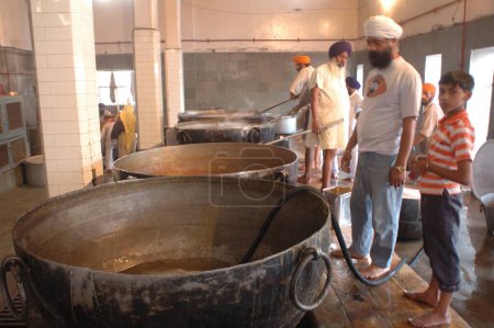Téléchargez les photos : Langar, cuisine communautaire, libre food-guru ka langar, la cuisine des gourous introduite par le gourou Amar Das pour faire fondre les barrières des castes et fournir de la nourriture gratuite à des milliers de pèlerins par le biais du service volontaire, Golden temple, Amritsar, Punjab, Inde - en image libre de droit
