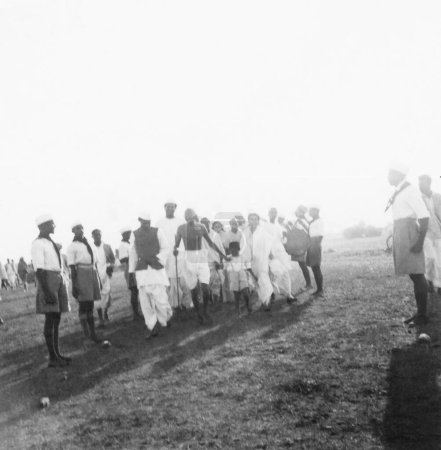 Téléchargez les photos : Mahatma Gandhi marchant avec son petit-fils Kahandas, Sushila Nayar et d'autres à l'ashram de Sevagram, 1939, Inde - en image libre de droit