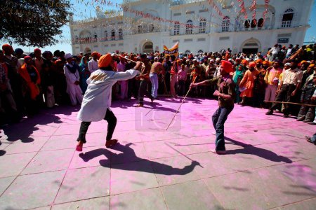 Foto de Karsevaks de Gurudwara realizando acrobacias con palos durante las celebraciones de Hola Mohalla en el sahib de Anandpur en el distrito de Rupnagar, Punjab, India - Imagen libre de derechos