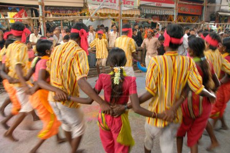 Téléchargez les photos : Vingt hommes et femmes forment un cercle faisant de la danse tribale au festival Navaratri, Dadar, Bombay Mumbai, Maharashtra, Inde - en image libre de droit