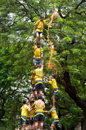 Téléchargez les photos : Pyramide humaine brisée dahi handi douche d'eau caillée et curcuma sur janmashtami festival à dadar, Bombay, Mumbai, Maharashtra, Inde - en image libre de droit