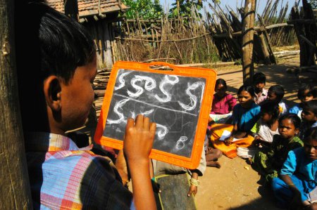 Téléchargez les photos : Des enfants tribaux apprennent l'alphabet télougou à l'école dirigée par une ONG Organisation non gouvernementale dans un village de l'Andhra Pradesh, en Inde - en image libre de droit